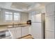 Bright kitchen featuring white appliances and cabinetry with a view of the window with shutters at 7300 Pirates Cove Rd # 1032, Las Vegas, NV 89145