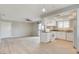 Open-concept living room and kitchen with updated white cabinetry, granite counters, and wood-look floors at 7300 Pirates Cove Rd # 1032, Las Vegas, NV 89145