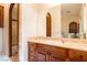Elegant bathroom vanity with marble countertop, wood cabinets, archway features, and modern fixtures at 8120 W Red Coach Ave, Las Vegas, NV 89129