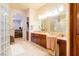 Luxurious bathroom with dual vanities, tiled floors, and a glass block shower at 8120 W Red Coach Ave, Las Vegas, NV 89129