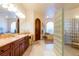 Elegant bathroom featuring dual sinks, a glass block shower, and neutral-toned walls at 8120 W Red Coach Ave, Las Vegas, NV 89129