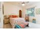 Bright bedroom with white furniture, colorful accents, and a window offering natural light at 8120 W Red Coach Ave, Las Vegas, NV 89129