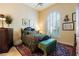 Cozy bedroom with dark wood furniture, patterned rug, and a window for natural light at 8120 W Red Coach Ave, Las Vegas, NV 89129
