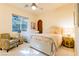 Cozy bedroom features bright, patterned furniture, a comfortable bed, and a window for natural light at 8120 W Red Coach Ave, Las Vegas, NV 89129