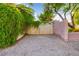 Gravel driveway leading to a gated entrance with lush greenery surroundings at 8120 W Red Coach Ave, Las Vegas, NV 89129