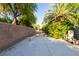 Wide driveway with lush greenery and block wall in a desert landscape at 8120 W Red Coach Ave, Las Vegas, NV 89129
