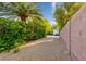Long gravel driveway with block wall leading to parking and lush greenery at 8120 W Red Coach Ave, Las Vegas, NV 89129