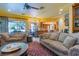 Spacious living room with comfortable sofas, ceiling fan, and seamless transition to dining and kitchen areas at 8120 W Red Coach Ave, Las Vegas, NV 89129