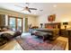 Relaxing bedroom includes a ceiling fan, lounge area, and access to the pool through French doors at 8120 W Red Coach Ave, Las Vegas, NV 89129