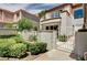 A beautiful two-story home with a balcony and a white fence surrounding the manicured landscaping at 8224 Horseshoe Bend Ln, Las Vegas, NV 89113