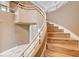 Beautiful curved staircase with wood treads and a modern white railing and landing at 8224 Horseshoe Bend Ln, Las Vegas, NV 89113