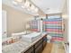 Bathroom featuring double sinks, a large mirror, granite countertops, and a colorful shower curtain at 9031 Jumping Jacks Ave, Las Vegas, NV 89178