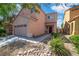 Two-story home showcasing a two-car garage, complemented by rock landscaping and blue skies at 9031 Jumping Jacks Ave, Las Vegas, NV 89178