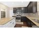 Modern kitchen with dark cabinets, stainless steel appliances, and granite countertops at 9031 Jumping Jacks Ave, Las Vegas, NV 89178