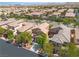 Expansive aerial view of a vibrant community with well-maintained homes, mature trees, and scenic mountain views at 9047 Harbor Wind Ave, Las Vegas, NV 89178
