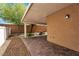 Covered backyard patio featuring paver flooring, a stone firepit, and mature trees at 9047 Harbor Wind Ave, Las Vegas, NV 89178