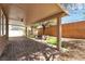 Covered backyard patio featuring paver flooring, a stone firepit, and mature trees at 9047 Harbor Wind Ave, Las Vegas, NV 89178