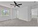 This spacious bedroom features soft carpeting, a large window, modern ceiling fan, and multiple entryways at 9047 Harbor Wind Ave, Las Vegas, NV 89178