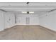 Spacious garage with white walls, concrete flooring, shelving, and a side entry door at 9047 Harbor Wind Ave, Las Vegas, NV 89178