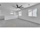 This loft area features plush carpeting, multiple windows for natural light, and a modern ceiling fan for comfort at 9047 Harbor Wind Ave, Las Vegas, NV 89178