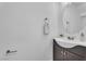 Stylish powder room featuring a modern vanity, round mirror, and neutral decor at 9047 Harbor Wind Ave, Las Vegas, NV 89178