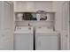 Functional laundry room equipped with a washer, dryer and storage shelves at 9070 Spring Mountain Rd # 114, Las Vegas, NV 89117