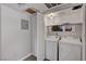 Functional laundry room equipped with a washer, dryer, storage cabinets and overhead lighting at 9070 Spring Mountain Rd # 114, Las Vegas, NV 89117