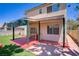 Inviting backyard with artificial turf, brick trim, covered patio and well-maintained landscaping at 9451 Natoma Station Pl, Las Vegas, NV 89123