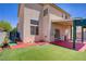 Spacious backyard featuring artificial turf, brick accents, and a covered patio at 9451 Natoma Station Pl, Las Vegas, NV 89123