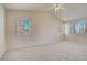 Spacious carpeted bedroom with ceiling fan and natural light from the windows at 9451 Natoma Station Pl, Las Vegas, NV 89123