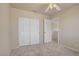 Neutral bedroom with plush carpet, ceiling fan, and sliding closet doors at 9451 Natoma Station Pl, Las Vegas, NV 89123