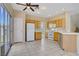 Bright kitchen with wooden cabinetry, white appliances, a ceiling fan, and sliding glass doors to the backyard at 9451 Natoma Station Pl, Las Vegas, NV 89123