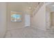Neutral living room with large window and staircase leading to the second floor at 9451 Natoma Station Pl, Las Vegas, NV 89123