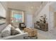 Staged living room with neutral paint, large windows, and a staircase leading to the second floor at 9451 Natoma Station Pl, Las Vegas, NV 89123