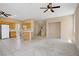 Open living space with kitchen, living room, and staircase with tile and carpet flooring and neutral paint at 9451 Natoma Station Pl, Las Vegas, NV 89123