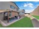 A backyard oasis featuring lush green lawn, covered patio with a BBQ, and a dining area at 1017 Huckburn Ave, Henderson, NV 89015