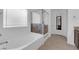 Modern bathroom featuring a soaking tub with a glass enclosure and stylish fixtures at 1017 Huckburn Ave, Henderson, NV 89015