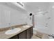 Well-lit bathroom with double sinks, a granite countertop, and a shower-tub combination at 1017 Huckburn Ave, Henderson, NV 89015