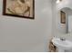 Powder room with a pedestal sink and framed floral artwork on the walls at 1017 Huckburn Ave, Henderson, NV 89015