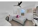 Cozy bedroom with a ceiling fan, window view, and decorative floral accents at 1017 Huckburn Ave, Henderson, NV 89015