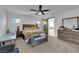 Spacious bedroom with neutral colors, a ceiling fan, and a barn door to the bathroom at 1017 Huckburn Ave, Henderson, NV 89015
