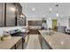 Open kitchen with stainless appliances, a large island, and brown cabinets creates a modern aesthetic at 1017 Huckburn Ave, Henderson, NV 89015