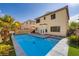 Backyard with a pool, palm trees, well-maintained landscaping, and pavers leading to a back door at 10428 Mulvaney Cir, Las Vegas, NV 89141