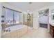 Bathroom features a corner shower and soaking tub adjacent to large window at 10428 Mulvaney Cir, Las Vegas, NV 89141