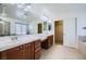 Bright bathroom with double vanity, soaking tub, and tiled floors at 10428 Mulvaney Cir, Las Vegas, NV 89141