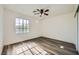 Bright bedroom with light walls, ceiling fan and wood-look flooring and a window with natural light at 10428 Mulvaney Cir, Las Vegas, NV 89141