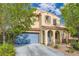 Charming two-story home with desert landscaping, blue shutters, and a matching garage door at 10428 Mulvaney Cir, Las Vegas, NV 89141