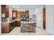 Well-equipped kitchen featuring an island with stone accents, stainless steel appliances, and wood cabinets at 10428 Mulvaney Cir, Las Vegas, NV 89141