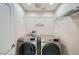 Laundry room with front loading washer and dryer and metal shelving at 10428 Mulvaney Cir, Las Vegas, NV 89141