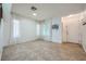 Inviting tiled living room featuring a staircase and large windows with sheer, white curtains at 10428 Mulvaney Cir, Las Vegas, NV 89141
